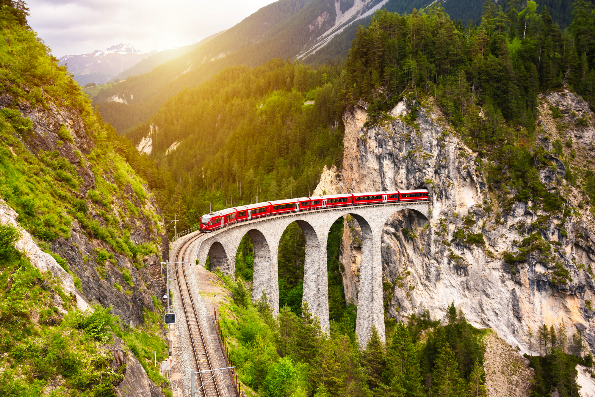 Swiss red train on viaduct in mountain, scenic ride