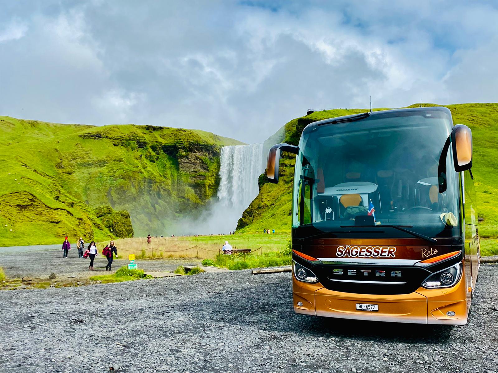 Car vor Wasserfall auf Island