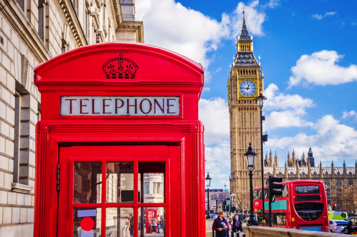 Rote Telefonzelle und Big Ben in London bei blauem Himmel.